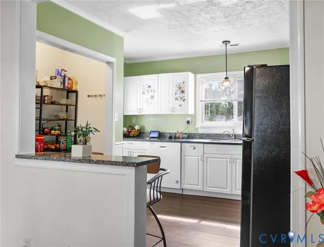 a kitchen with stainless steel appliances granite countertop a refrigerator and a stove top oven