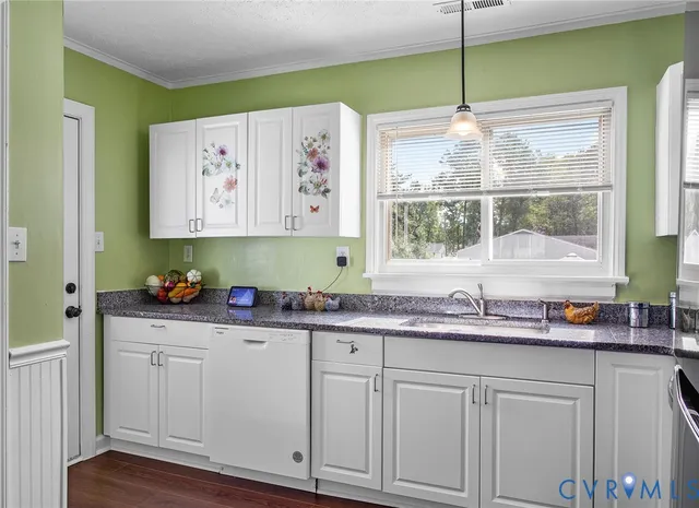 a kitchen with white cabinets and window