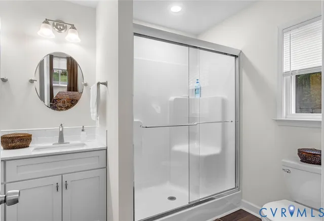 a bathroom with a sink a mirror a glass door and shower