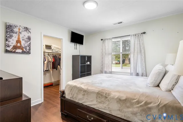 a spacious bedroom with a bed and a flat screen tv