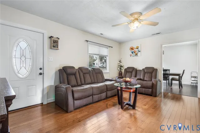 a living room with furniture a wooden floor and a chandelier