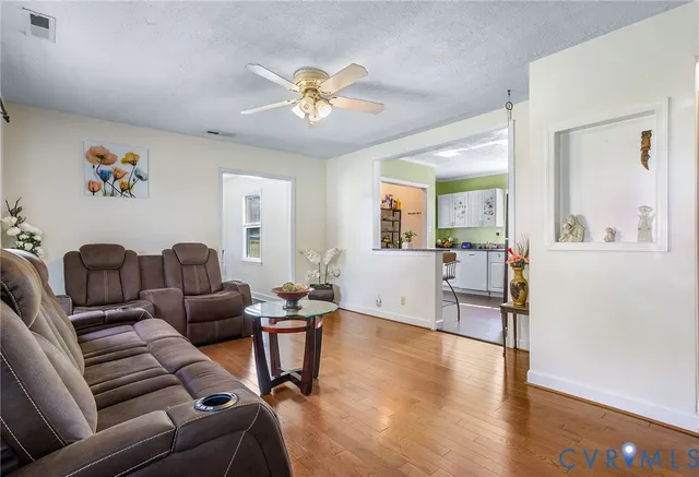 a living room with furniture and wooden floor