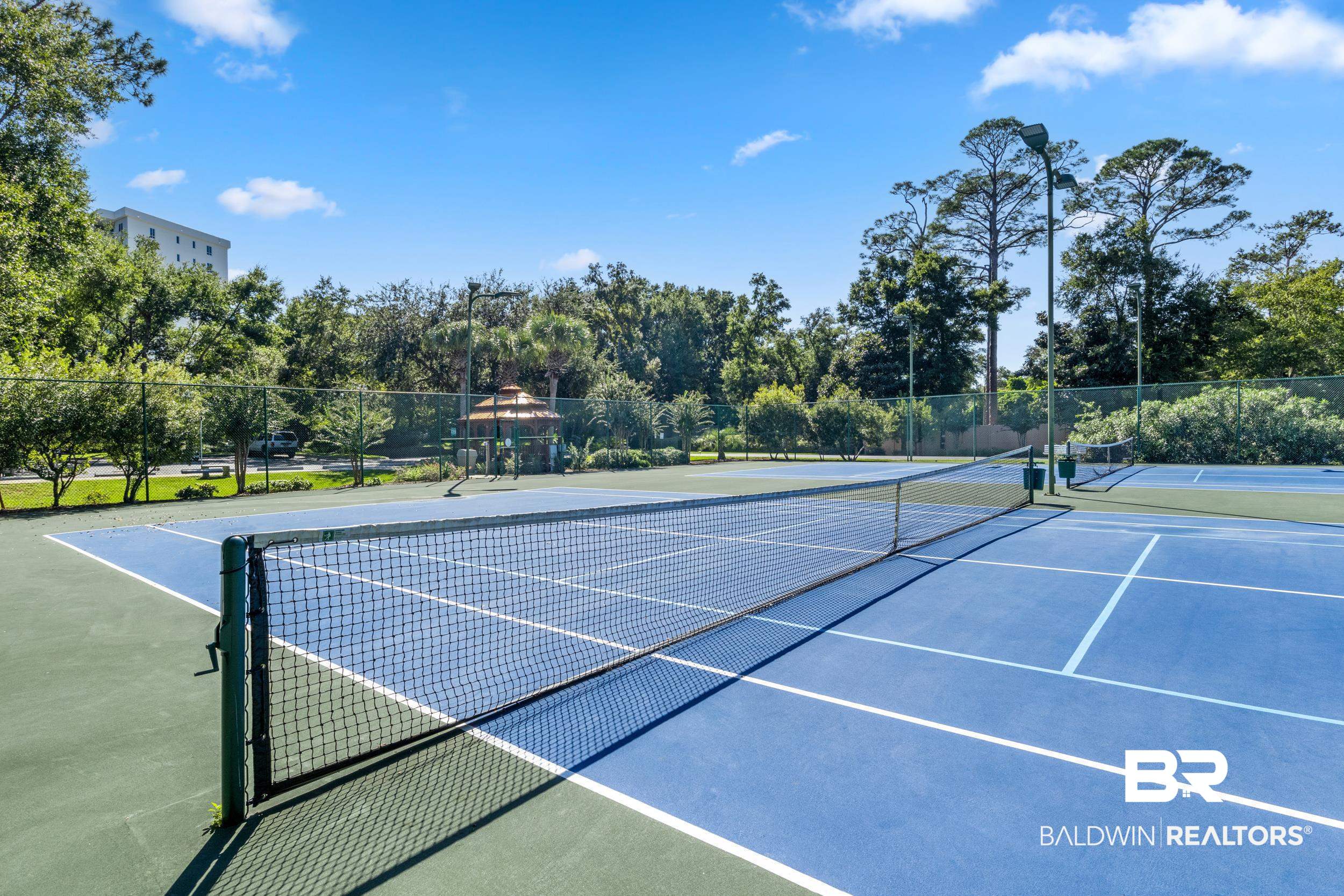 28250 Canal Road, Unit 307 Orange Beach, AL 36561 - Photo 52 of 56 View of tennis court with view of wooded area