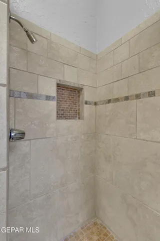 a bathroom with a tub sink vanity granite and mirror