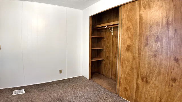 a view of backyard with large trees and plants