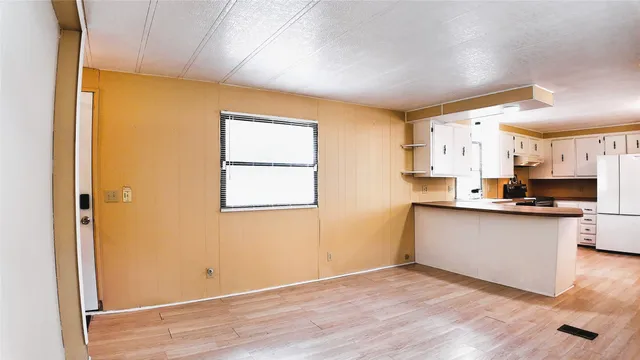 a kitchen with stainless steel appliances a refrigerator a stove a sink and white cabinets