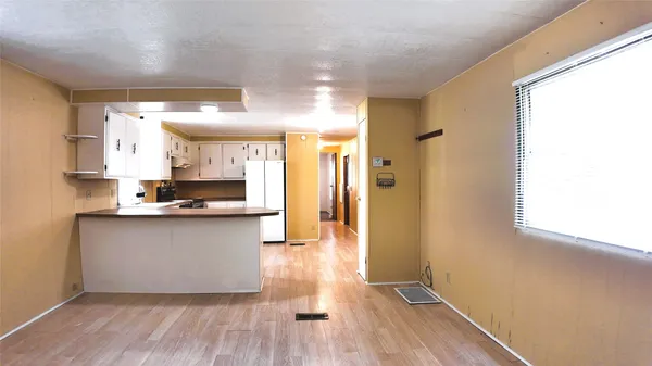 a kitchen with stainless steel appliances a refrigerator and white cabinets
