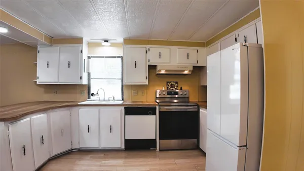 a kitchen with a sink a cabinets and wooden floor