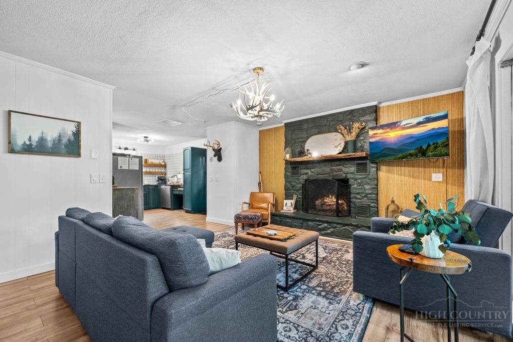 216 Saddle Lane Deep Gap, NC 28618 - Photo 10 of 44 a living room with furniture a chandelier and a fireplace