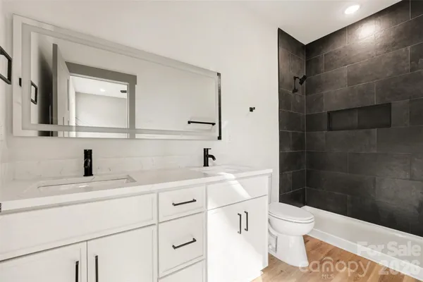 a bathroom with a sink a toilet and a mirror