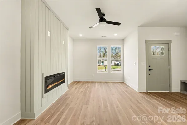 a view of wooden floor a ceiling fan and windows in a room