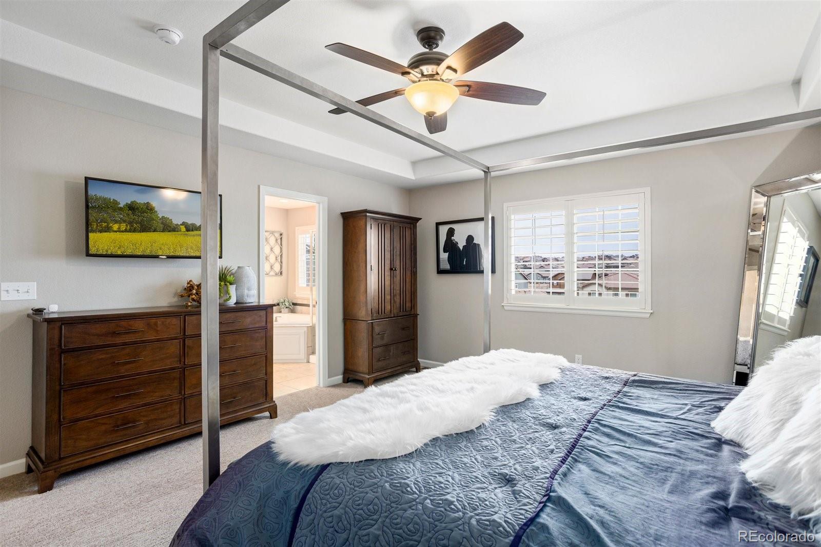 690 Tiger Lily Way Highlands Ranch, CO 80126 - Photo 15 of 38 a bedroom with a bed chandelier and a window