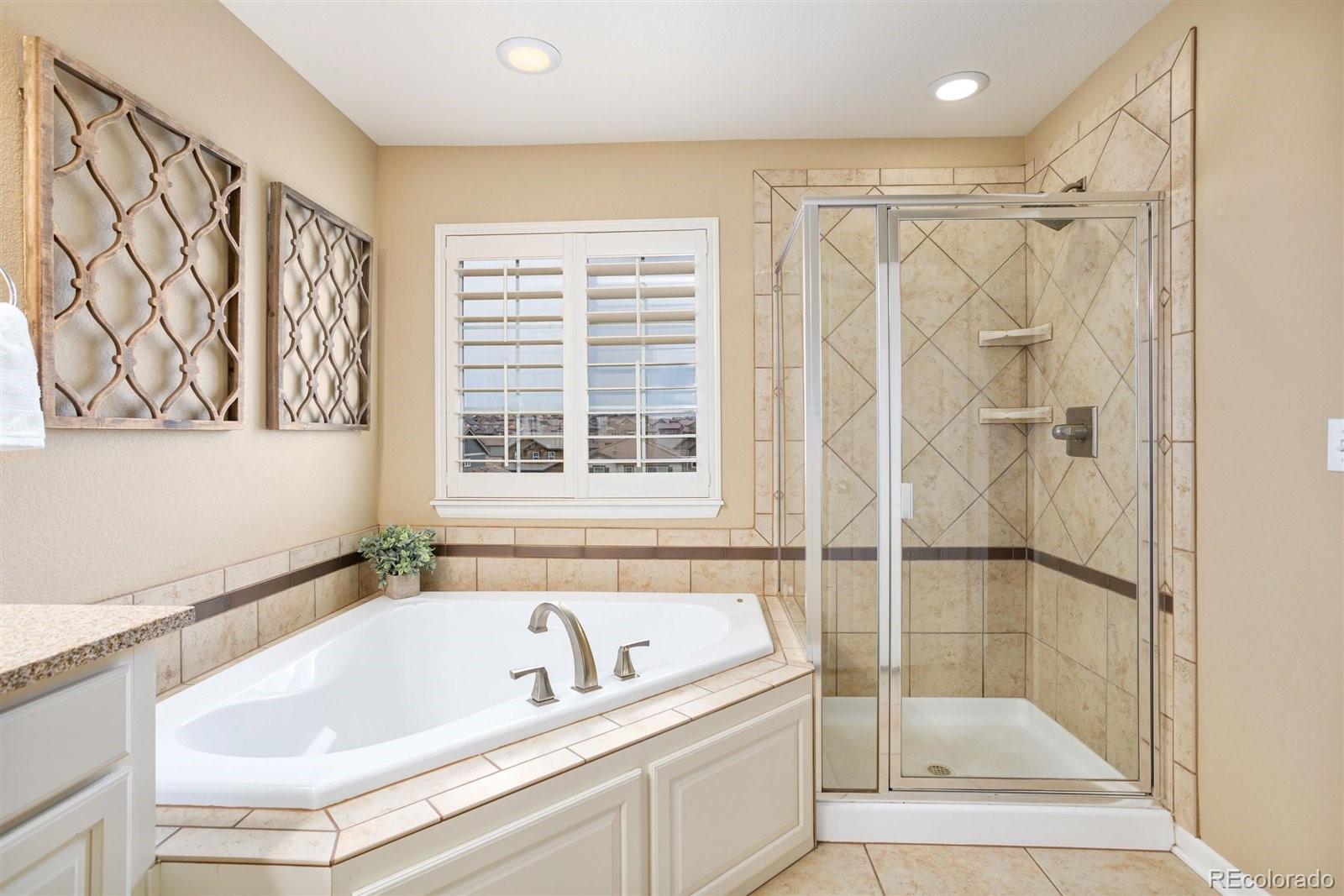 690 Tiger Lily Way Highlands Ranch, CO 80126 - Photo 16 of 38 a bathroom with a tub and a shower