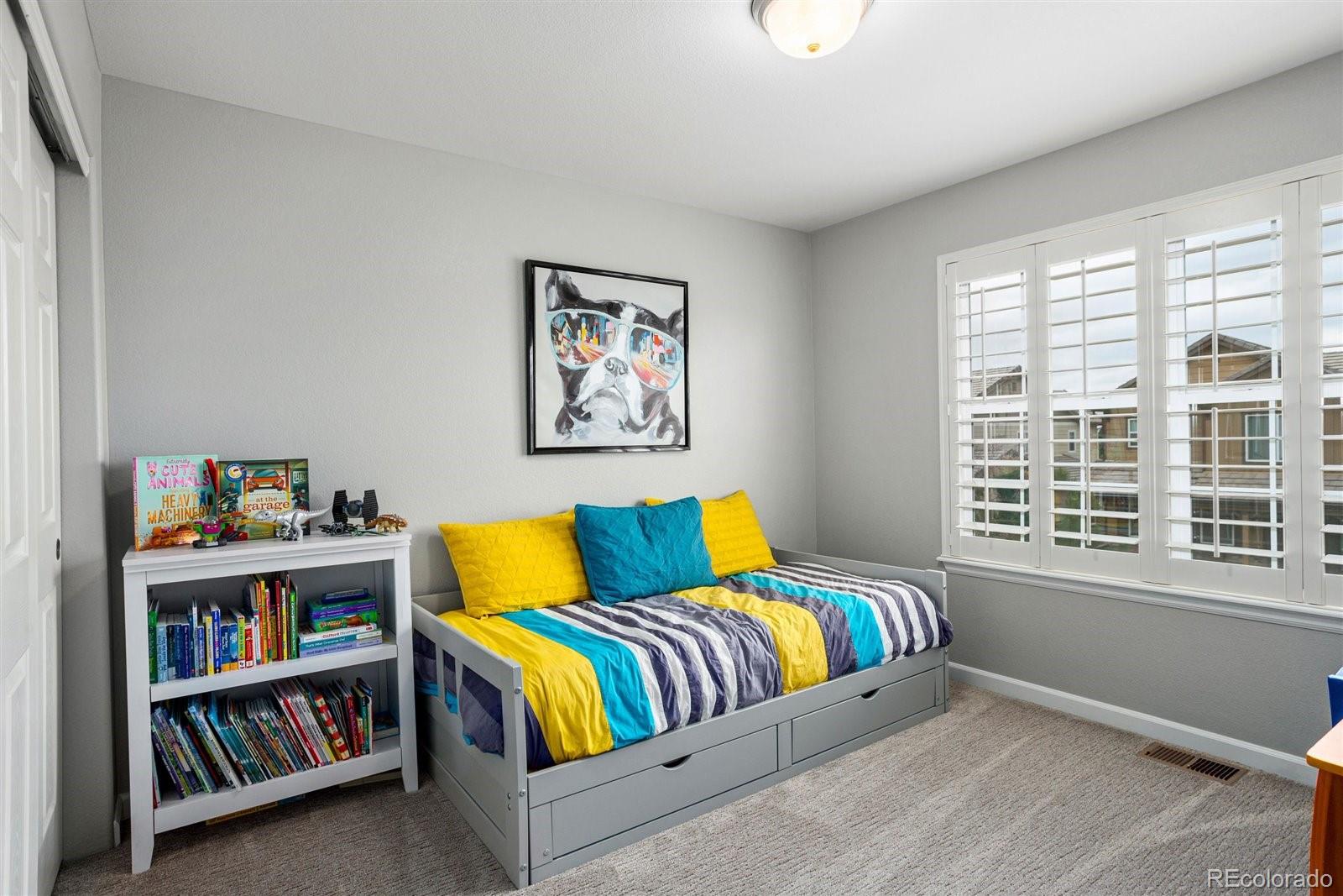 690 Tiger Lily Way Highlands Ranch, CO 80126 - Photo 19 of 38 a bedroom with a bed and a book shelf