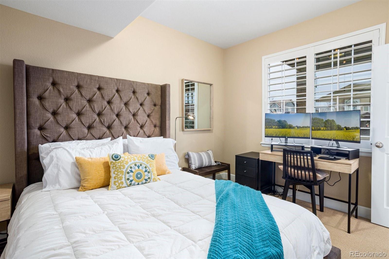 690 Tiger Lily Way Highlands Ranch, CO 80126 - Photo 27 of 38 a bedroom with a bed and a table in it