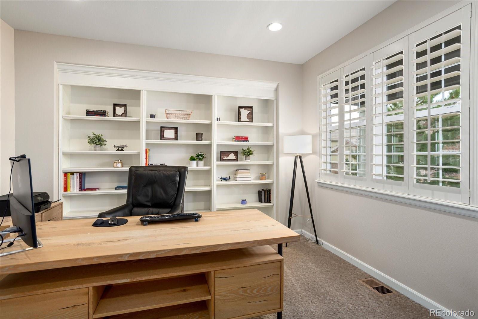 690 Tiger Lily Way Highlands Ranch, CO 80126 - Photo 3 of 38 a room with a desk and a book shelf