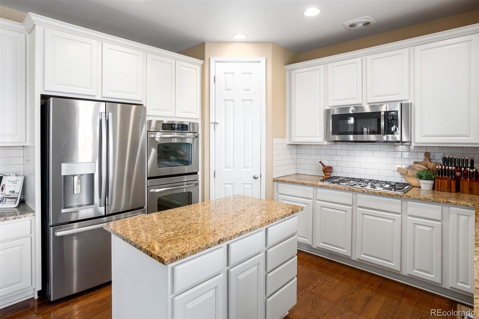 690 Tiger Lily Way Highlands Ranch, CO 80126 - Photo 4 of 38 a kitchen with stainless steel appliances granite countertop a refrigerator stove and microwave