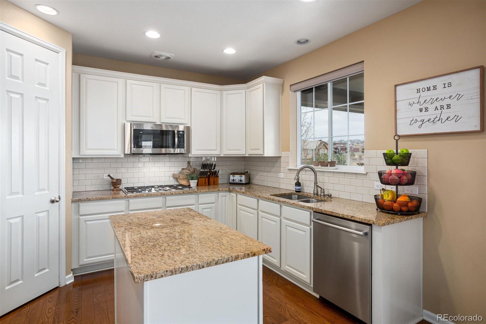 690 Tiger Lily Way Highlands Ranch, CO 80126 - Photo 5 of 38 a kitchen with stainless steel appliances granite countertop a sink stove and cabinets