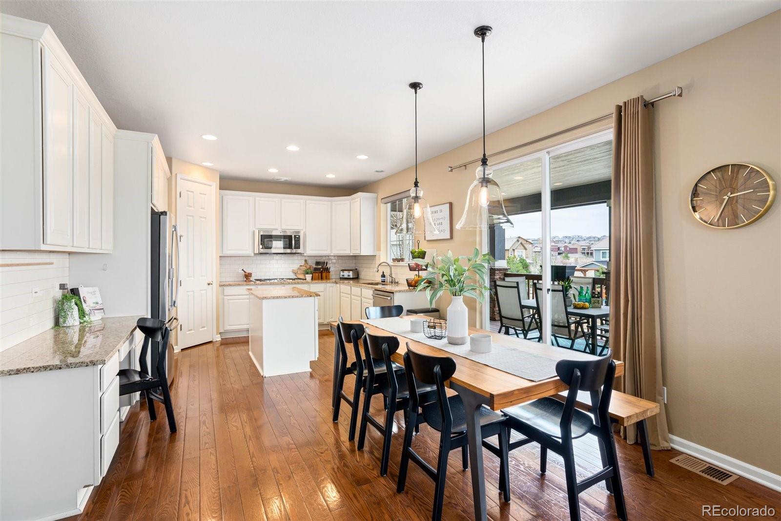 690 Tiger Lily Way Highlands Ranch, CO 80126 - Photo 6 of 38 a dining room with furniture a chandelier and wooden floor