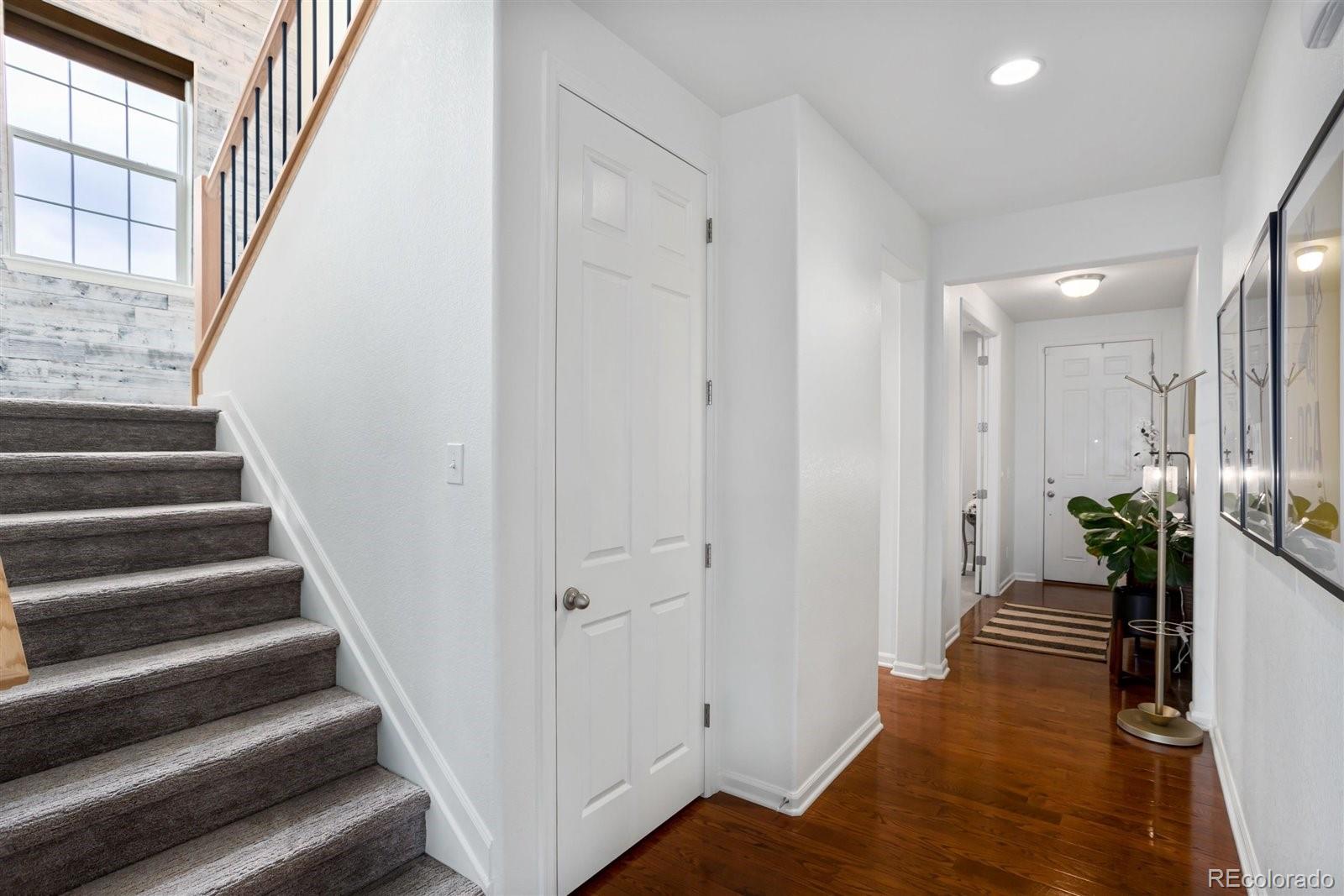 690 Tiger Lily Way Highlands Ranch, CO 80126 - Photo 10 of 38 a view of a hallway with wooden floor and staircase