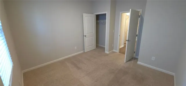 an empty room with closet and windows