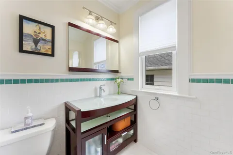 a bathroom with a sink a toilet and mirror