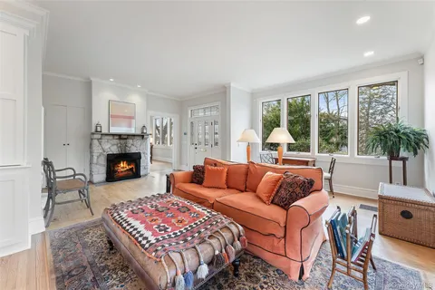 a living room with furniture fireplace and a large window