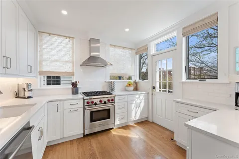 a kitchen with stainless steel appliances white cabinets and a window