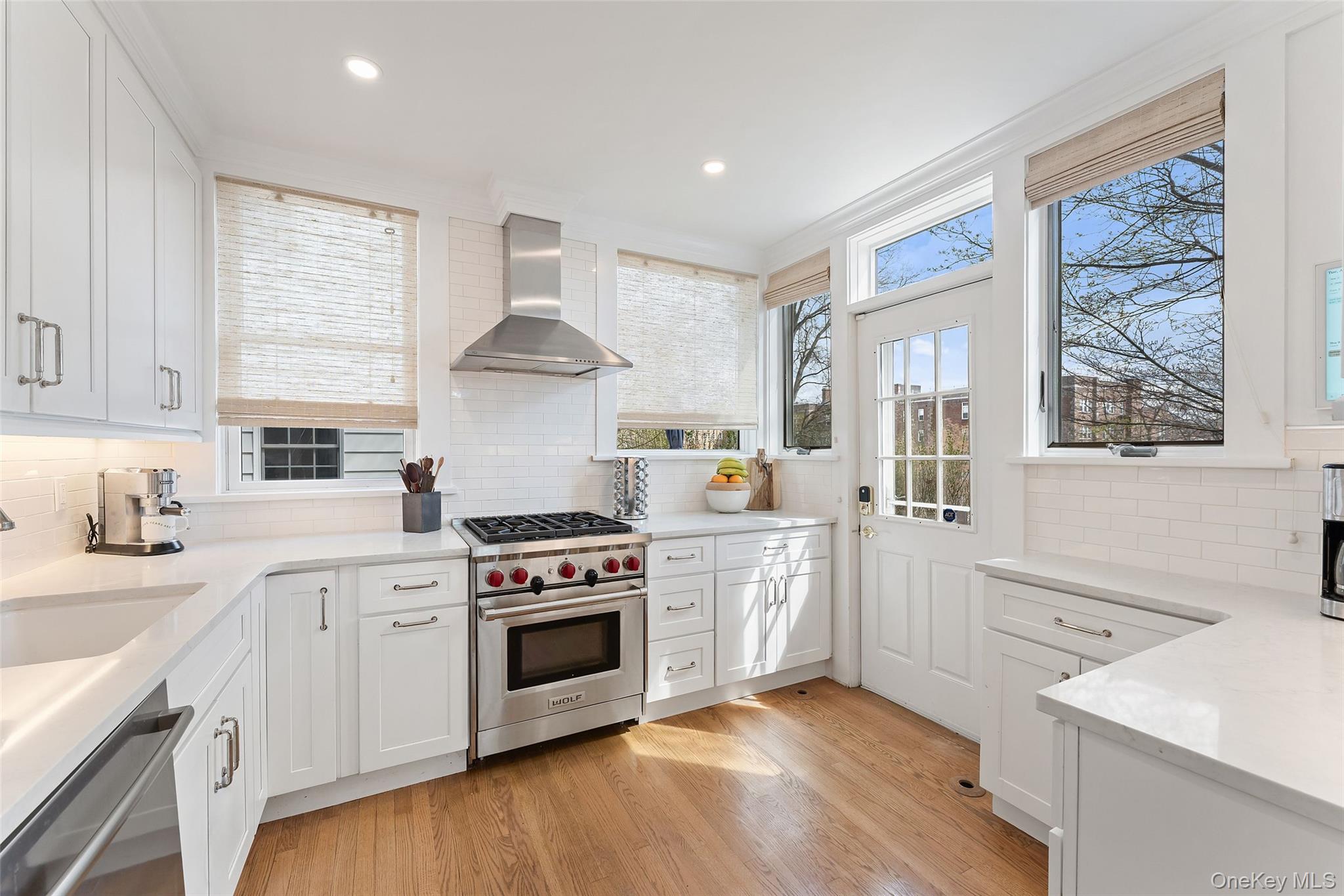 25 Merriam Avenue Bronxville, NY 10708 - Photo 8 of 26 a kitchen with stainless steel appliances white cabinets and a window
