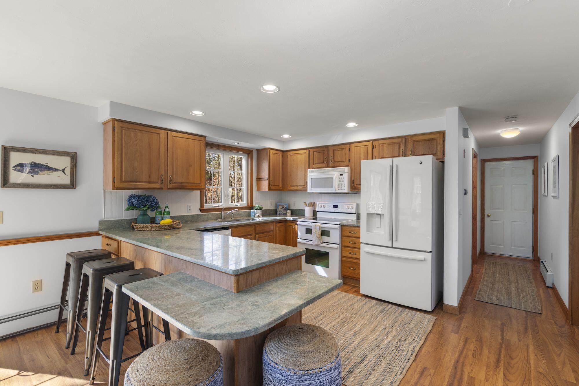 263 Spruce Road Harwich, MA 02645 - Photo 11 of 53 a kitchen with stainless steel appliances granite countertop a refrigerator a stove and a wooden floors