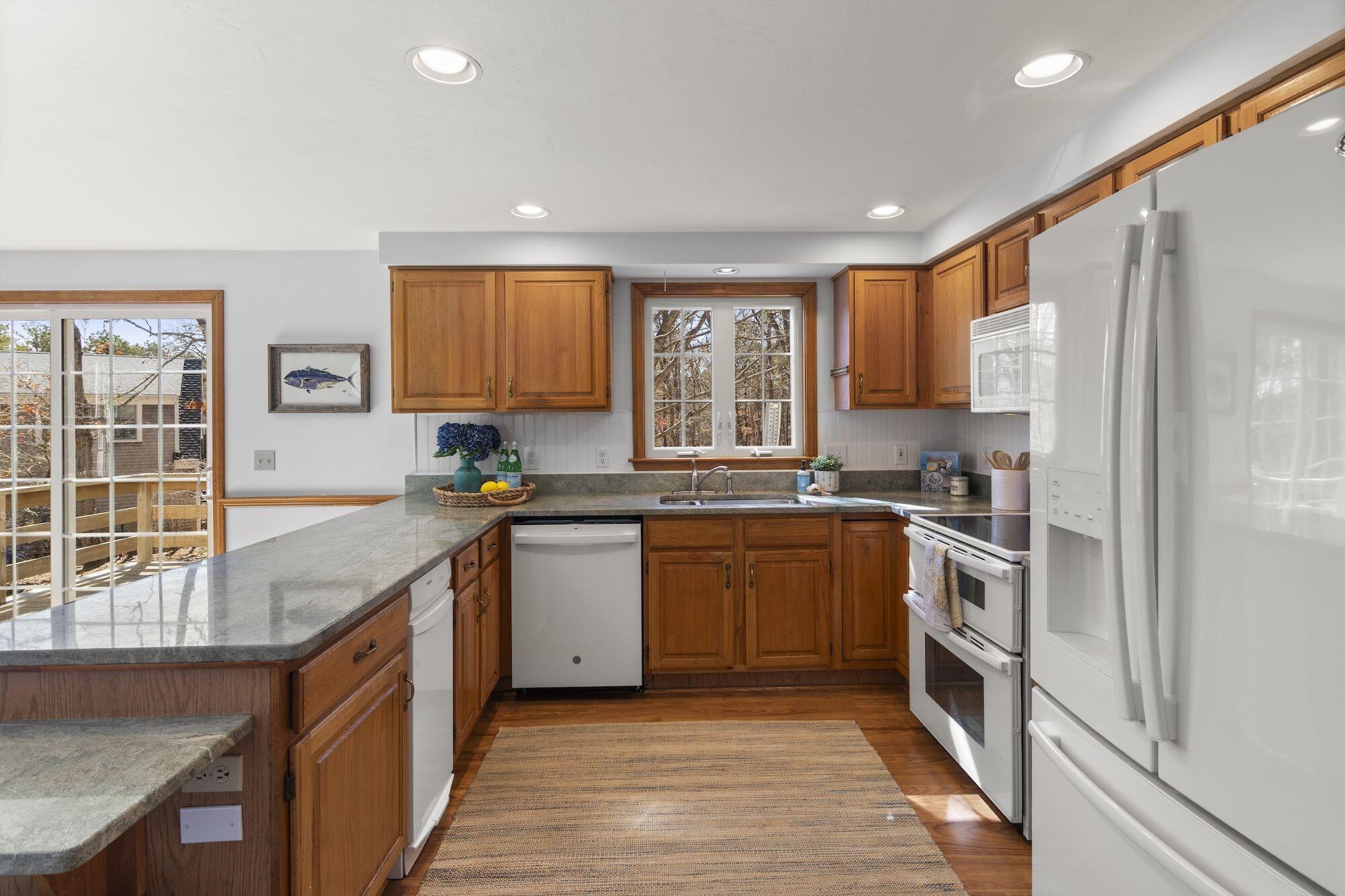 263 Spruce Road Harwich, MA 02645 - Photo 12 of 53 a kitchen with stainless steel appliances granite countertop a stove a sink and a refrigerator