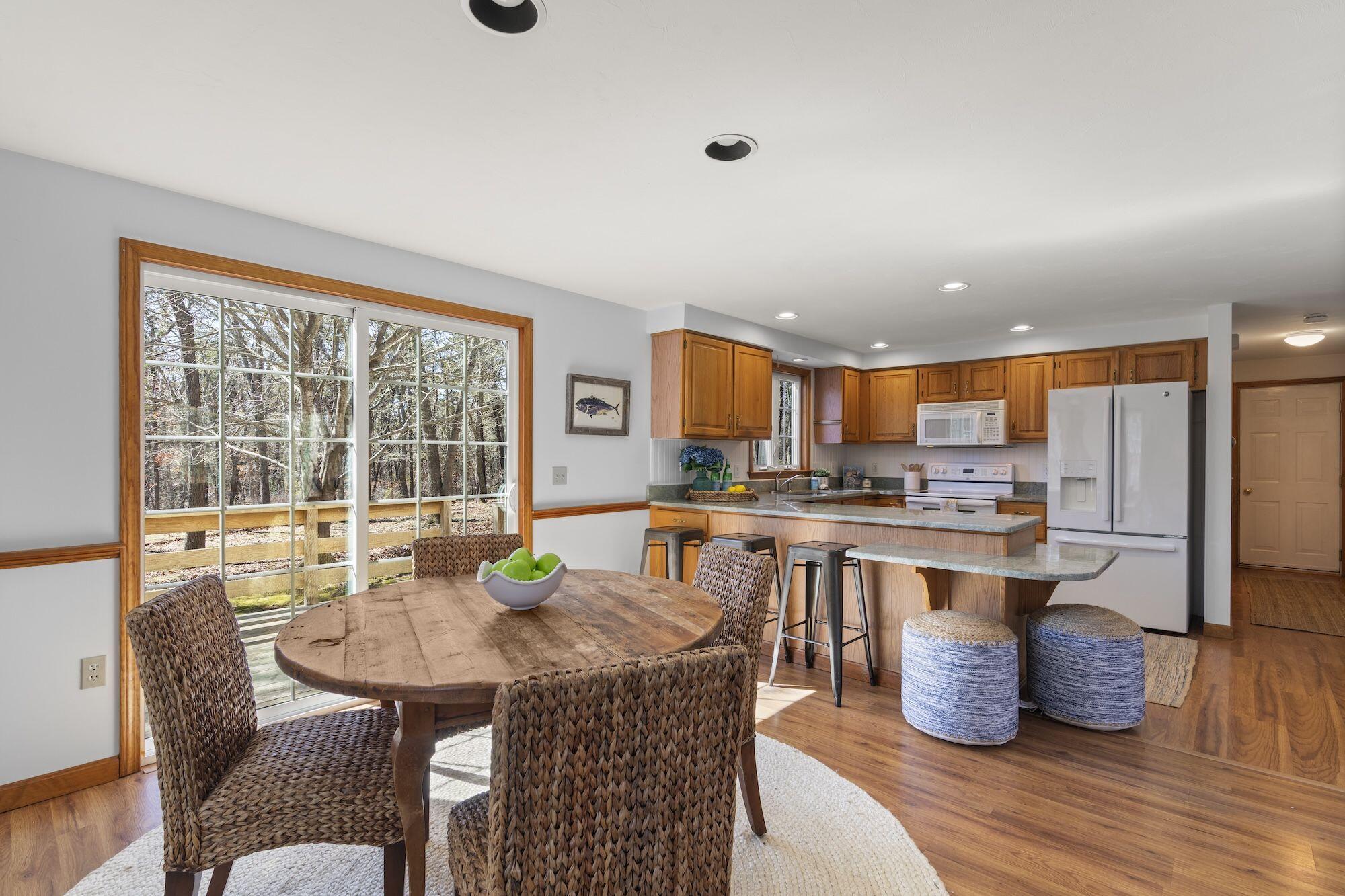 263 Spruce Road Harwich, MA 02645 - Photo 8 of 53 a kitchen with a table chairs and wooden floor