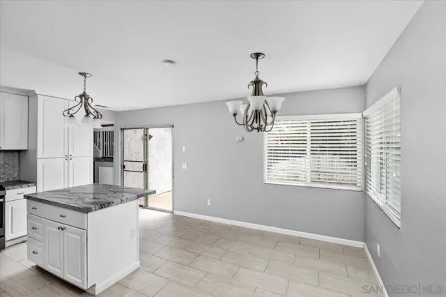 a kitchen with kitchen island granite countertop a stove and a refrigerator