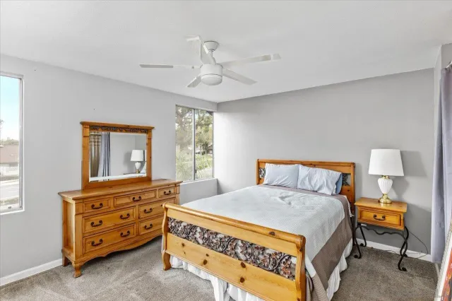 a bedroom with a bed a dresser and a window