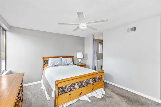 a bed sitting in a bedroom next to a window with a chandelier