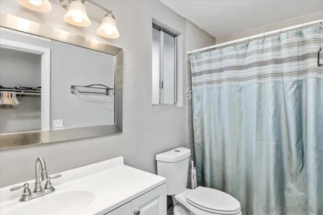 a bathroom with a sink a toilet and shower curtain