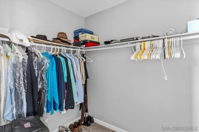 a view of walk in closet with clothes and shoes