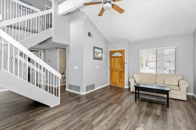 a living room with furniture and a wooden floor