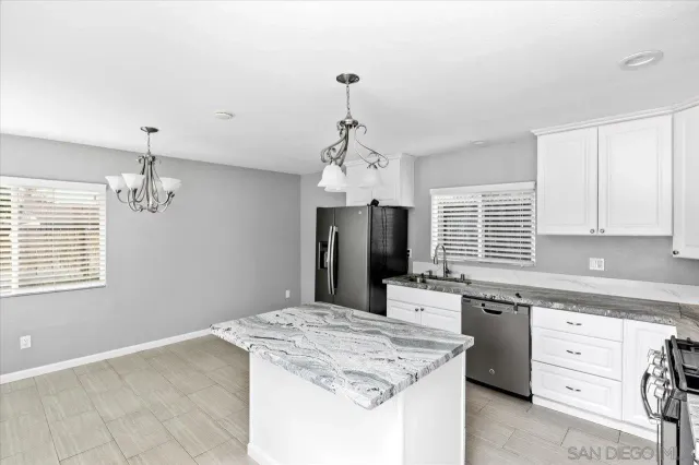 a kitchen with kitchen island stainless steel appliances a sink stove and refrigerator