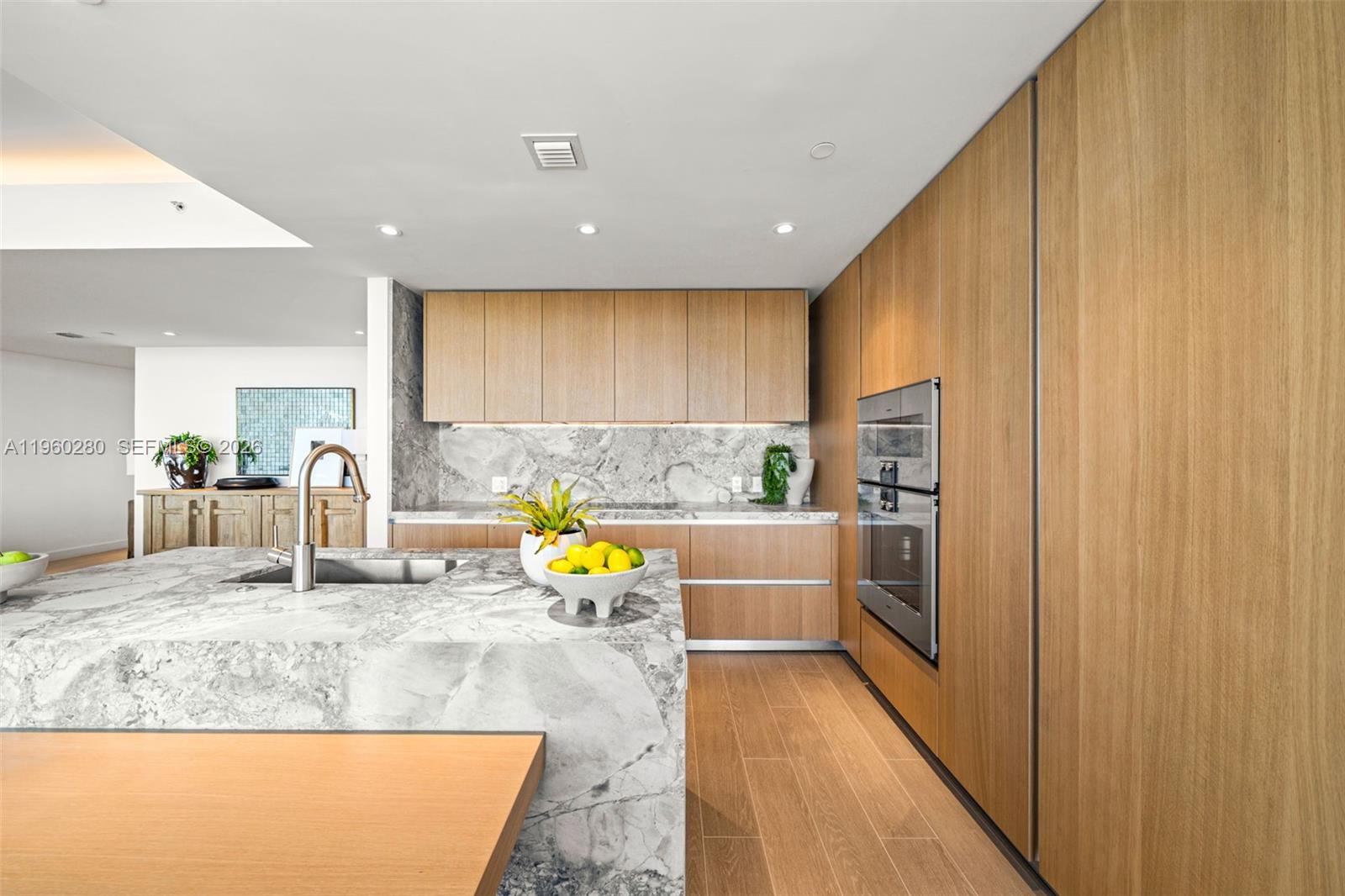 500 Alton Road, Unit 2203 Miami Beach, FL 33139 - Photo 8 of 36 a kitchen with stainless steel appliances granite countertop sink and wooden cabinets