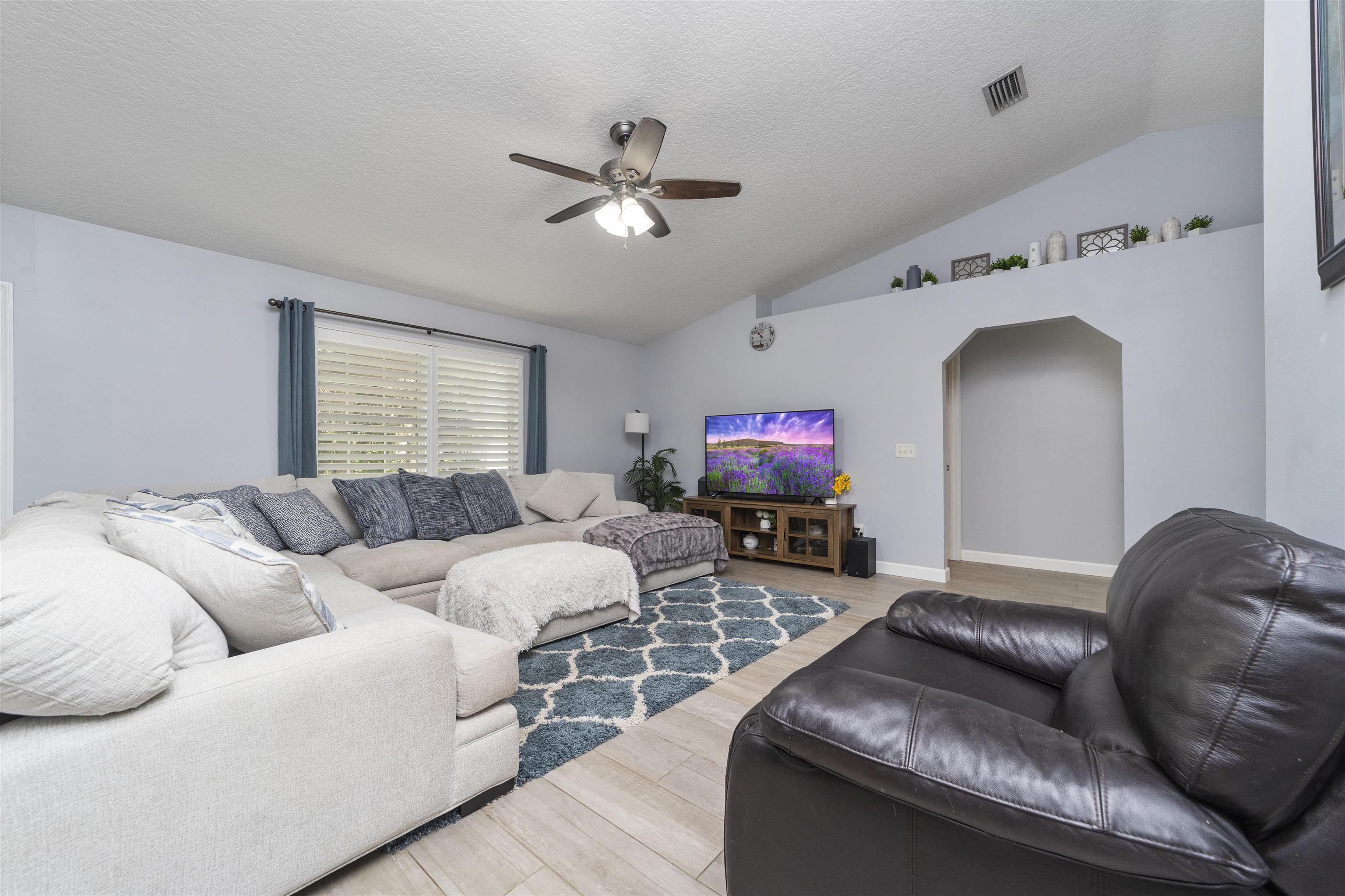 845 Wildwood Drive St. Augustine, FL 32086 - Photo 13 of 58 a living room with furniture a fireplace and a flat screen tv