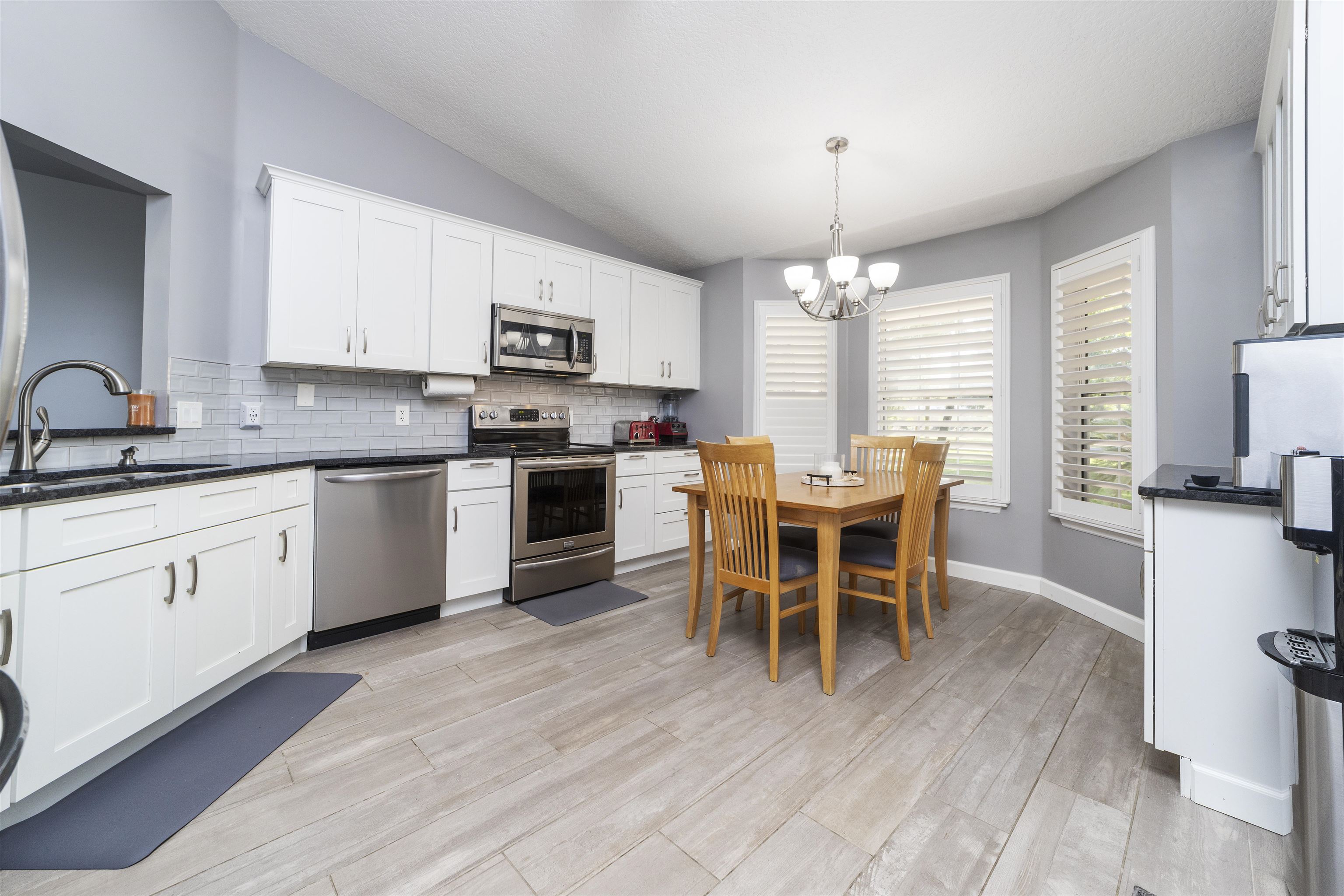 845 Wildwood Drive St. Augustine, FL 32086 - Photo 16 of 58 a open dining room with stainless steel appliances granite countertop a stove top oven a sink dishwasher a dining table and chairs with wooden floor