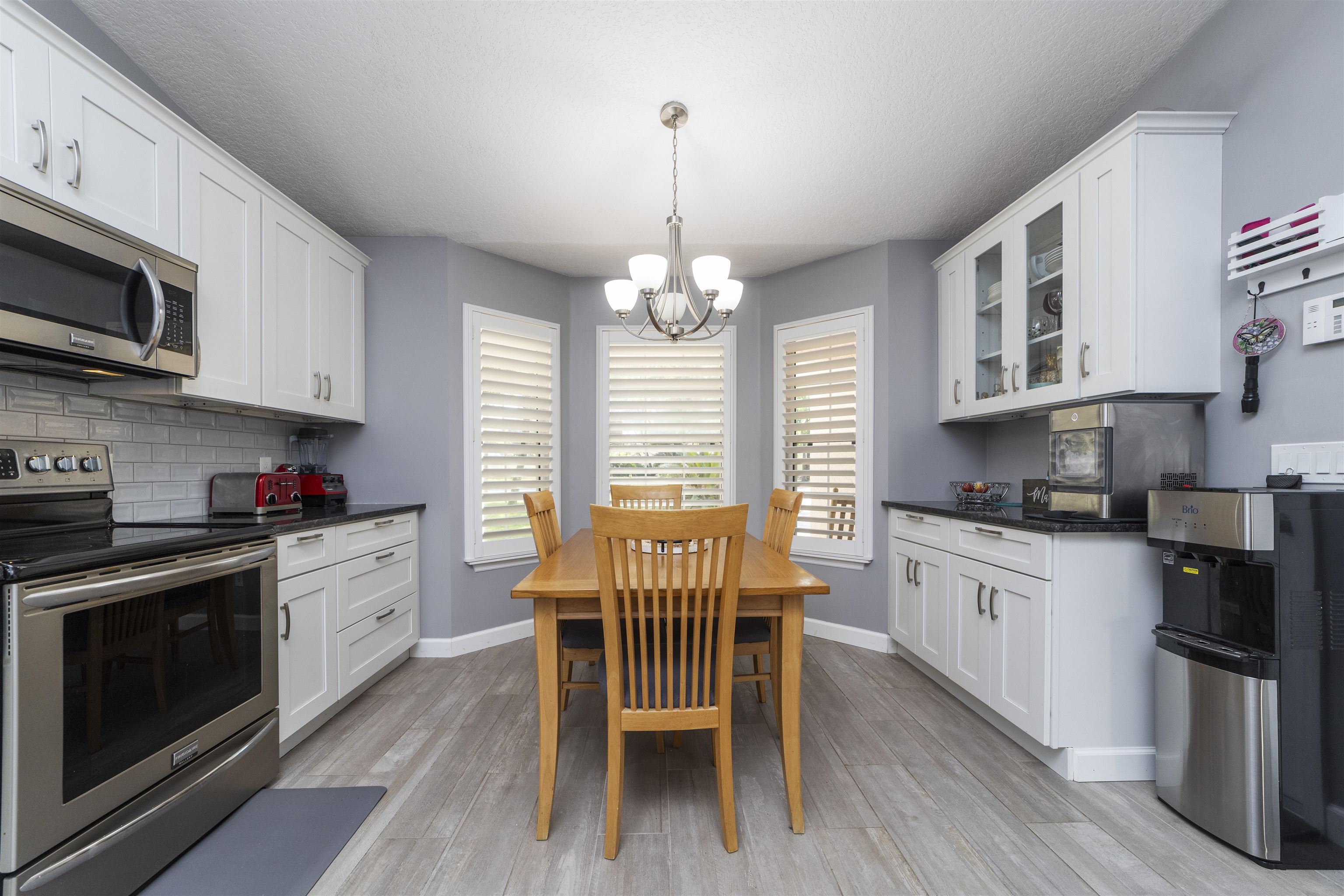 845 Wildwood Drive St. Augustine, FL 32086 - Photo 19 of 58 a kitchen with stainless steel appliances granite countertop a stove a sink dishwasher a microwave oven with cabinets and wooden floor