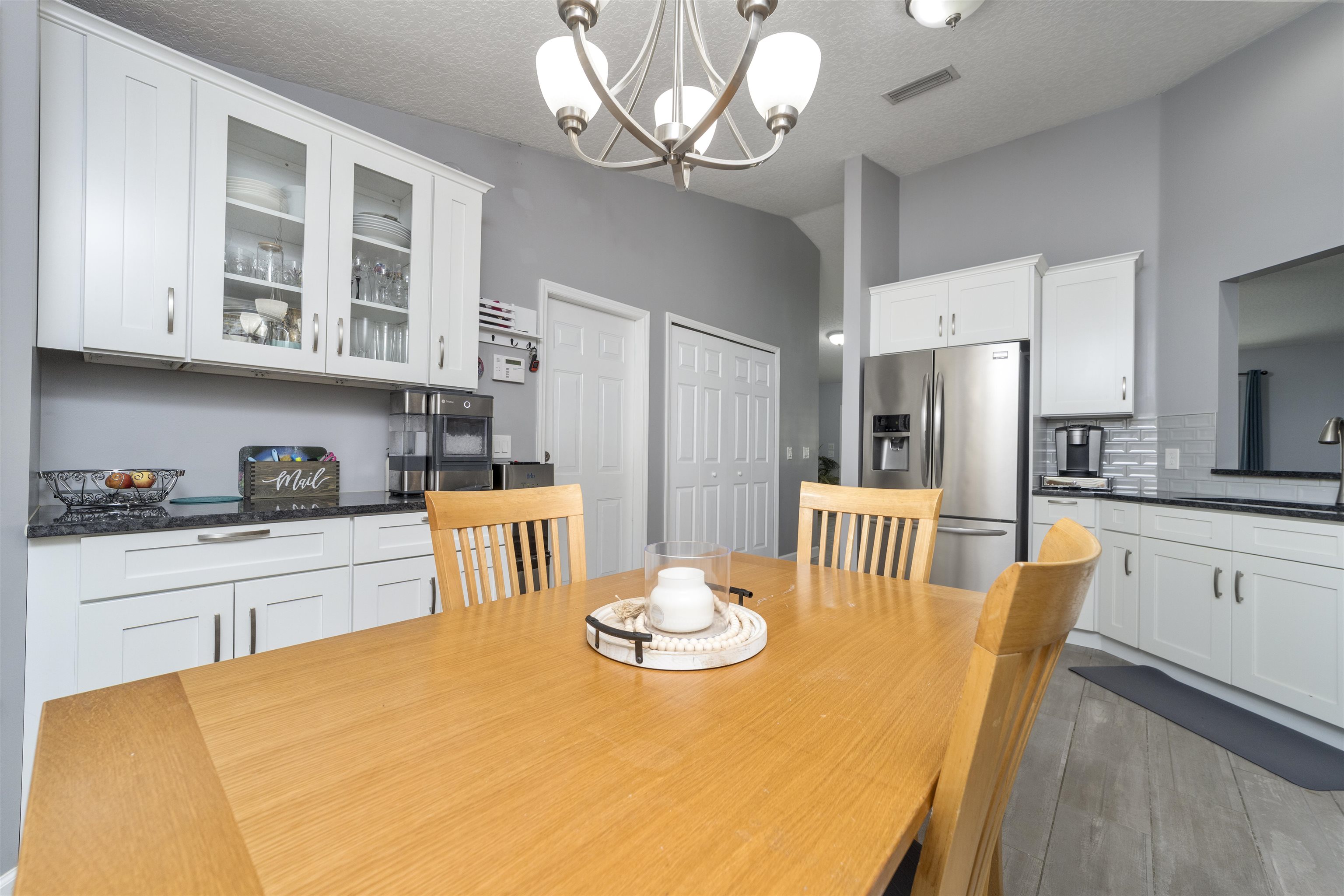 845 Wildwood Drive St. Augustine, FL 32086 - Photo 22 of 58 a kitchen with stainless steel appliances granite countertop a dining table chairs and a refrigerator