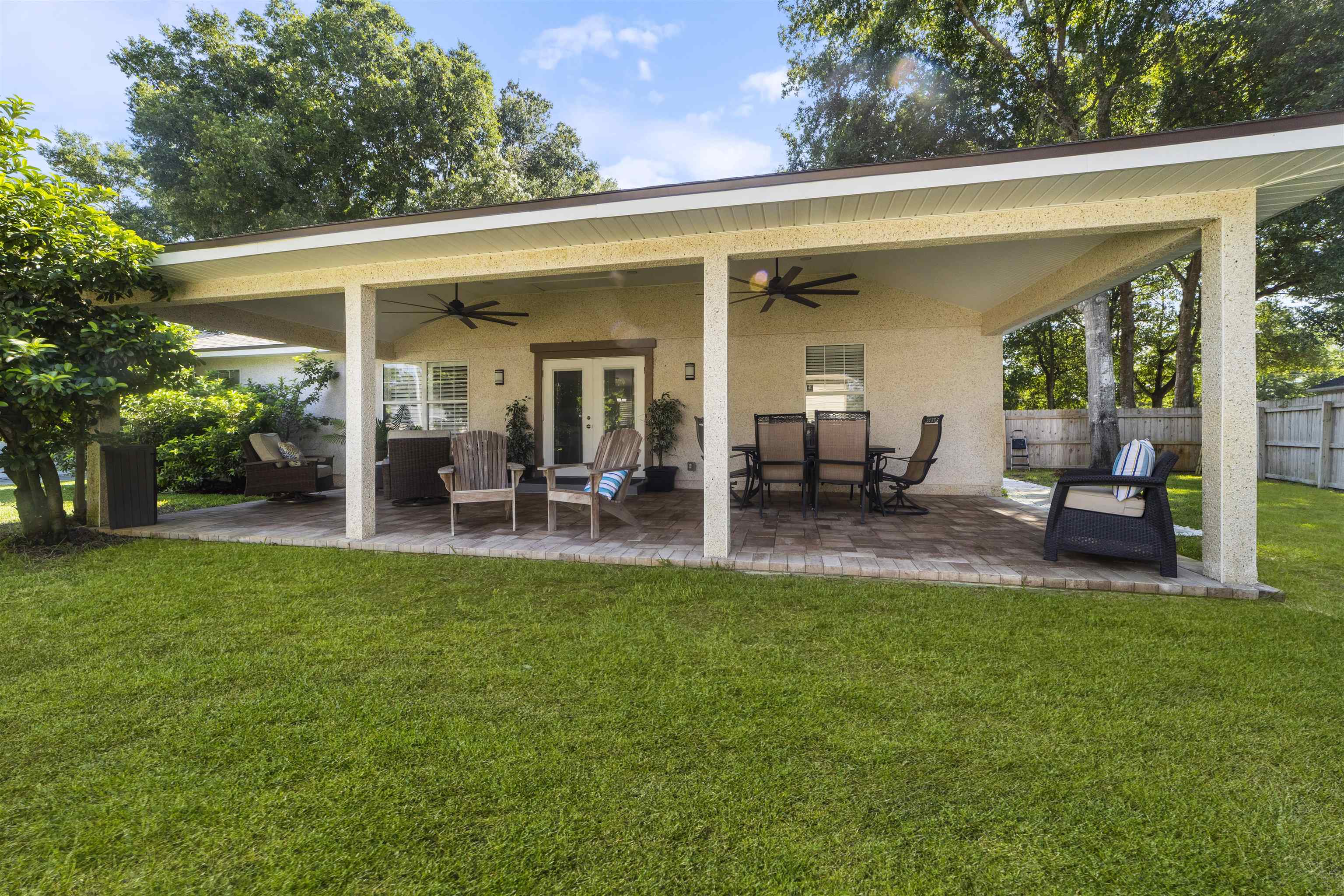 845 Wildwood Drive St. Augustine, FL 32086 - Photo 43 of 58 a view of a patio with table and chairs potted plants and a large tree