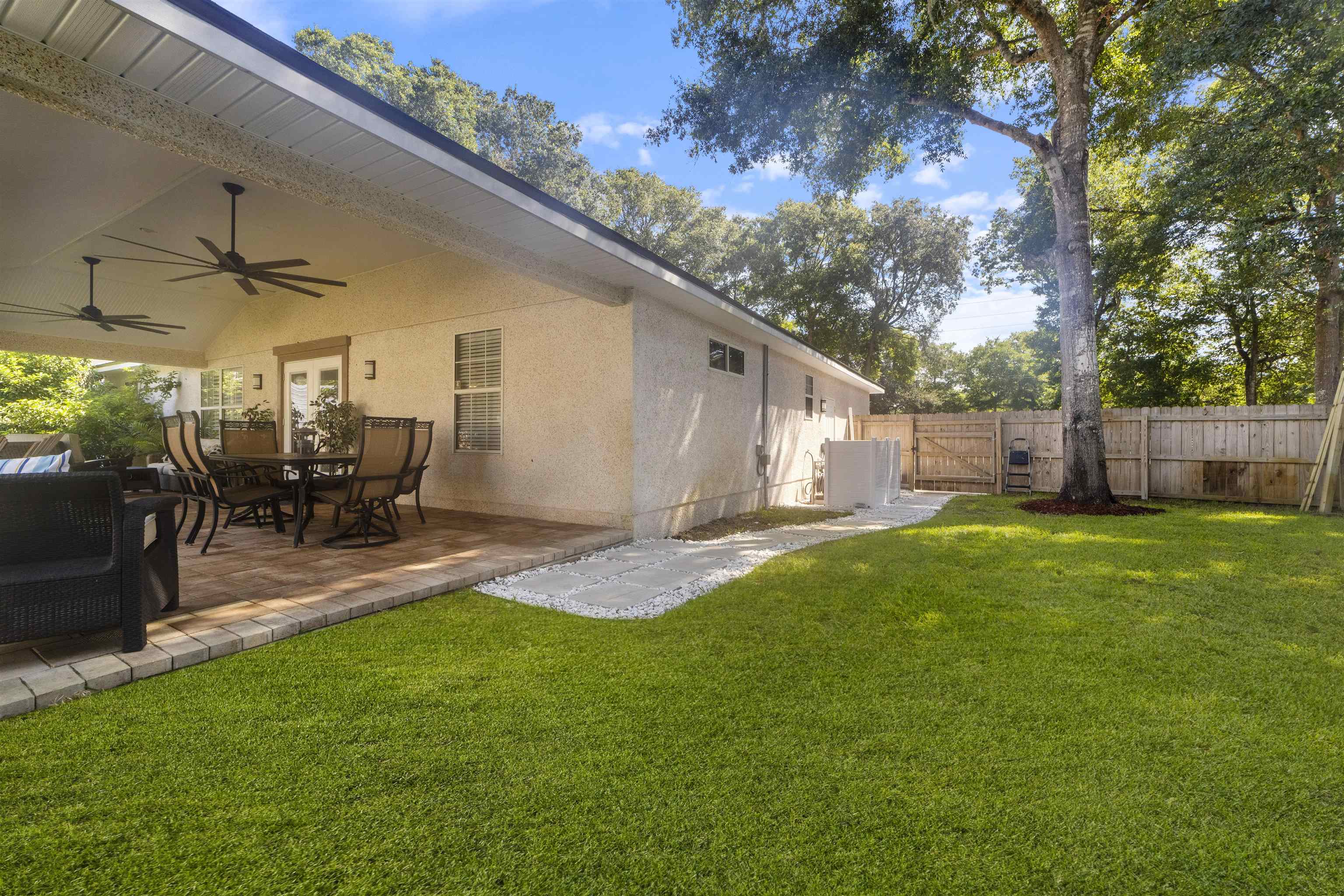 845 Wildwood Drive St. Augustine, FL 32086 - Photo 46 of 58 a view of a backyard with table and chairs potted plants and a palm tree