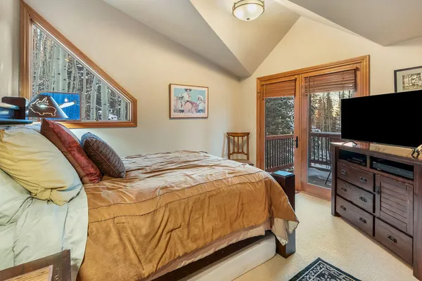 a bedroom with a bed a mirror and a large window