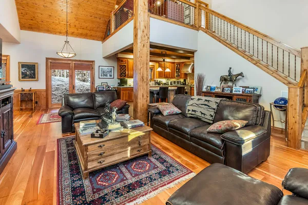 a living room with furniture a flat screen tv and kitchen view