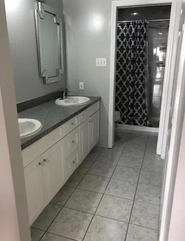 a bathroom with a granite countertop sink a toilet and a mirror