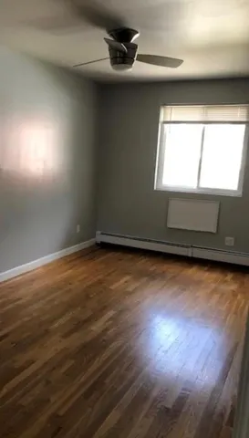 en empty room with wooden floor and windows